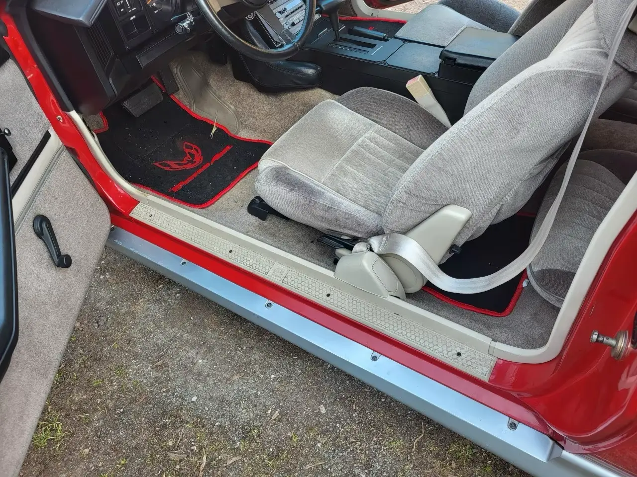 Fahrerseitiger Einstieg mit Fussraum, Fussmatte und grauem Sitz
