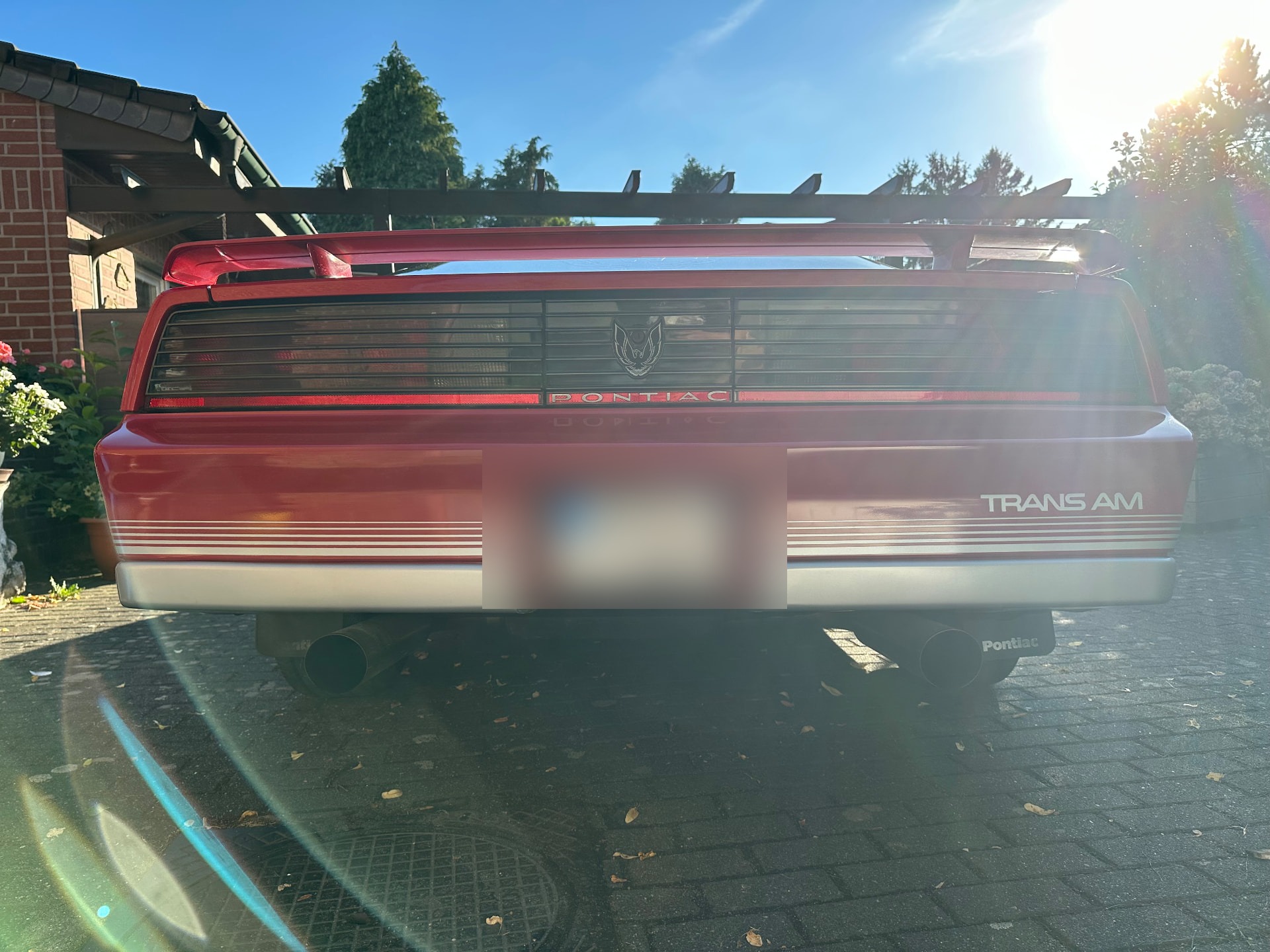 Heckansicht eines roten Pontiac Trans Am mit durchgehender Heckleuchtenblende und Spoiler