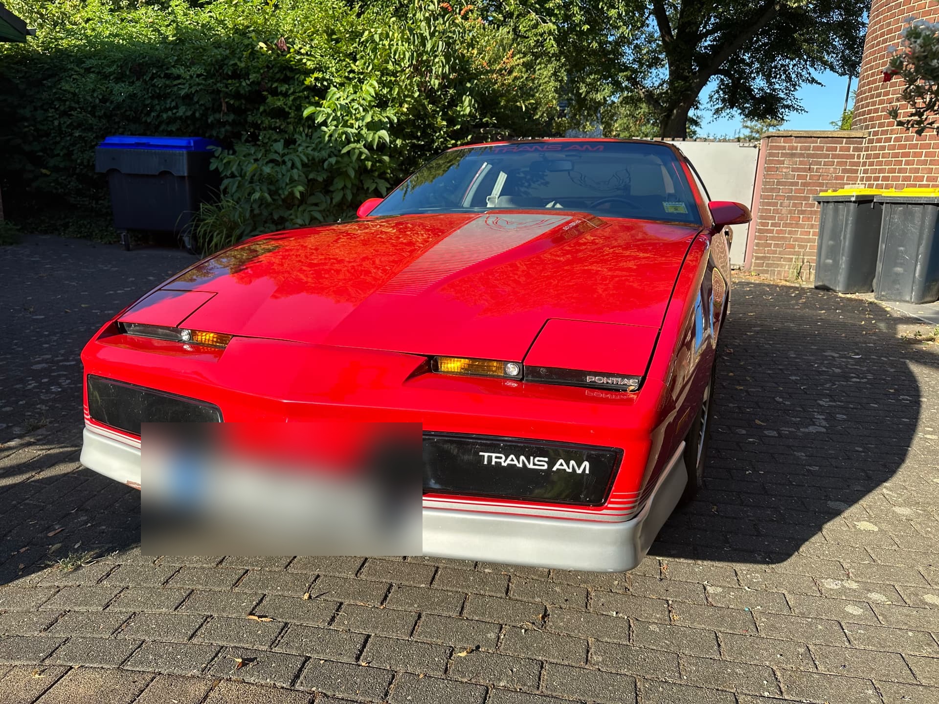 Frontansicht eines roten Pontiac Trans Am mit Klappscheinwerfern und Trans-Am-Schriftzug