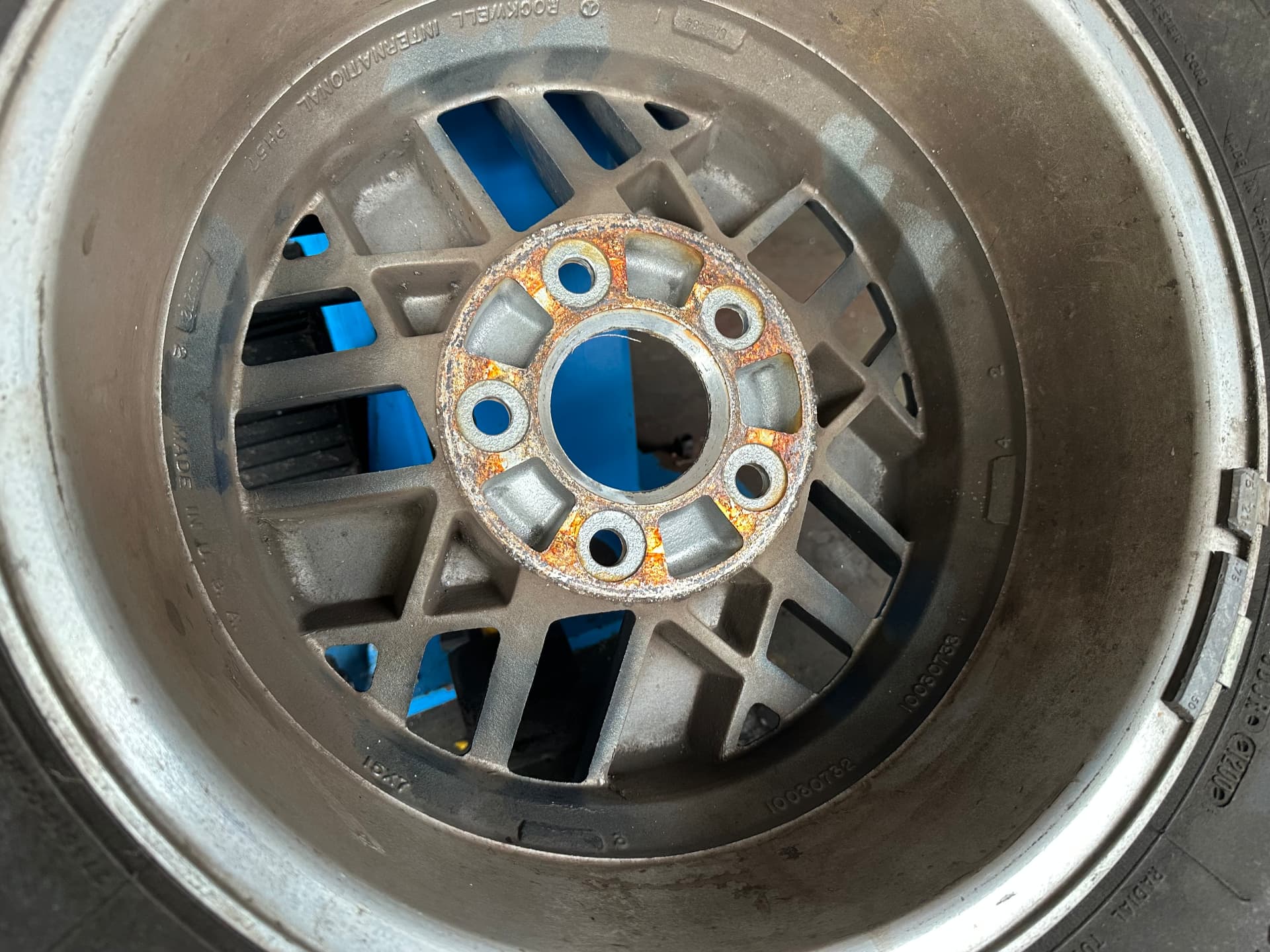 Rückseite einer Aluminiumfelge mit Gussmarkierungen und Flugrost am Nabensitz