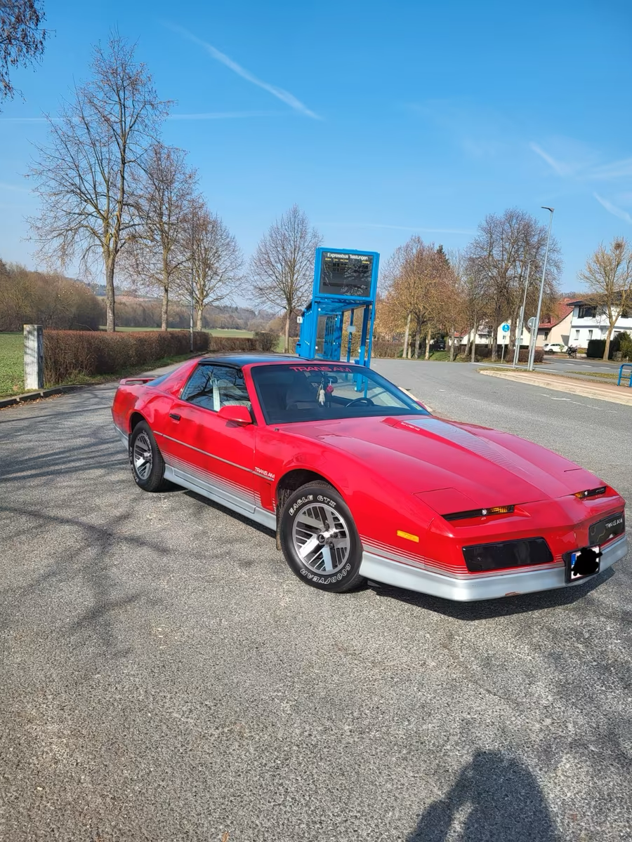 Roter Pontiac Trans Am in Front-Dreiviertelansicht auf einem Parkplatz