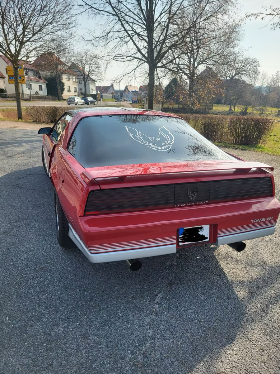 Heckansicht eines roten Pontiac Trans Am mit Lamellenblende, Spoiler und Doppelendrohren